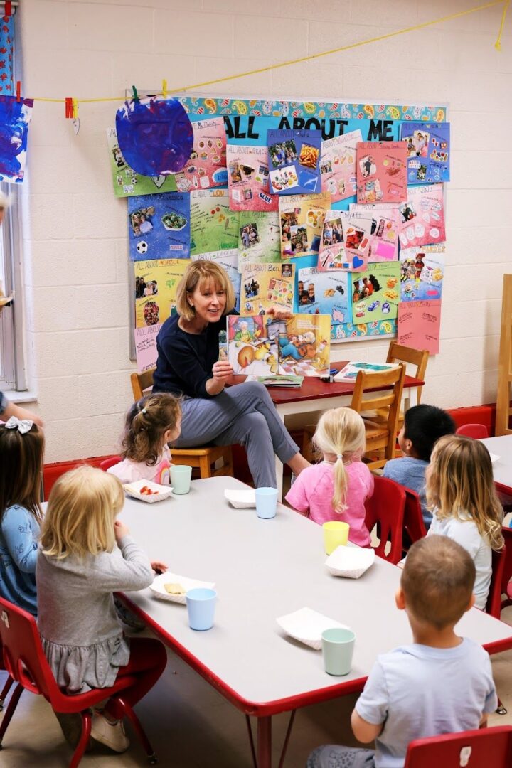 a teacher reading a children’s book in front of kids